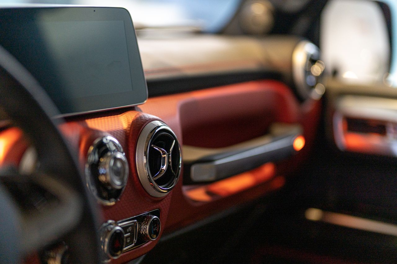 Close-up of a modern cars interior focusing on the digital dashboard and air vents.